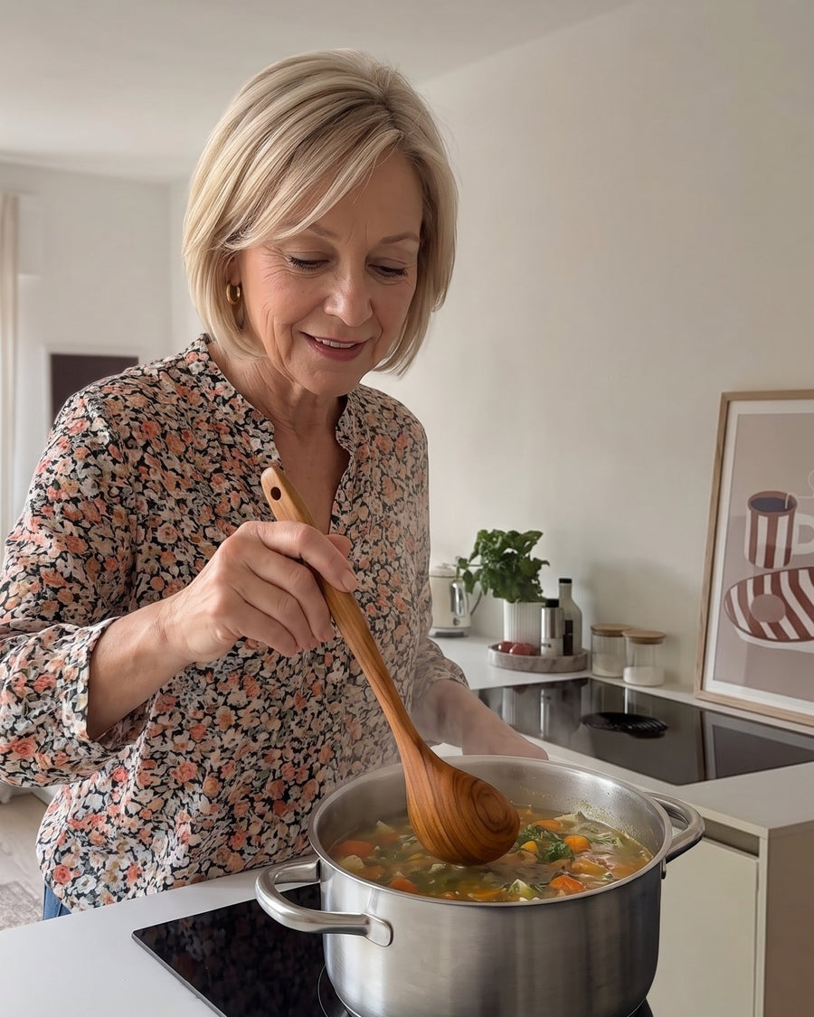 Frau rührt Gemüsesuppe mit einem Teak-Löffel um