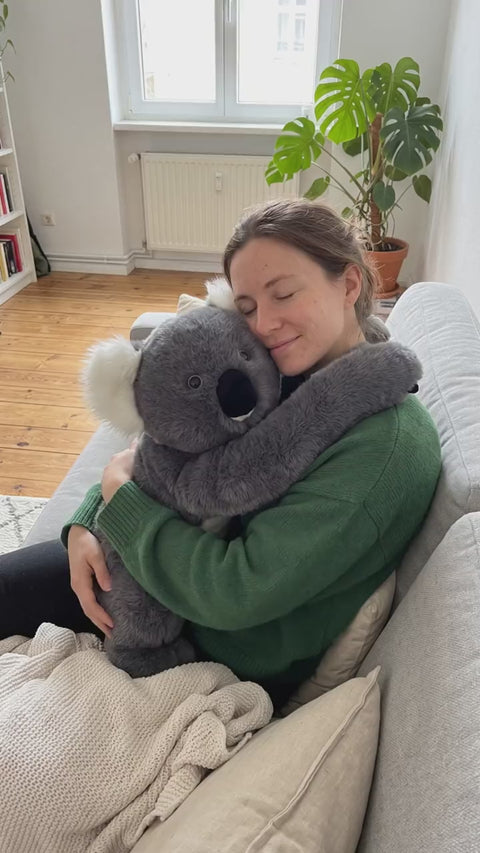 Frau umarmt Koala-Gewichtskuscheltier